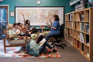 Middle school book study where students surround teacher.