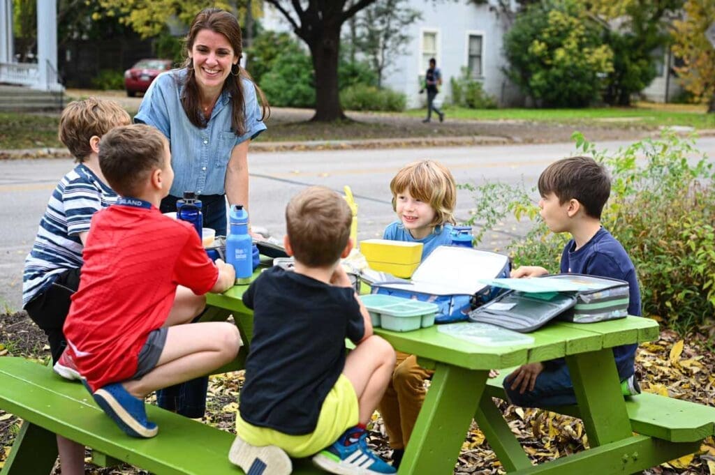 Associate Director of private school laughing with kindergarteners.