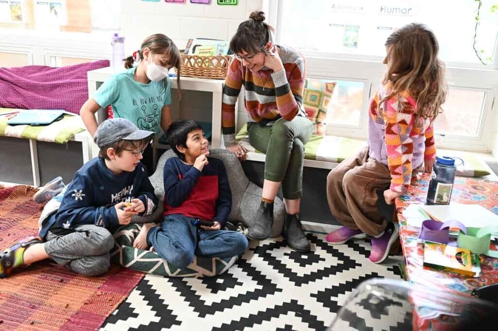 Teacher chats with kids in mixed-aged class.