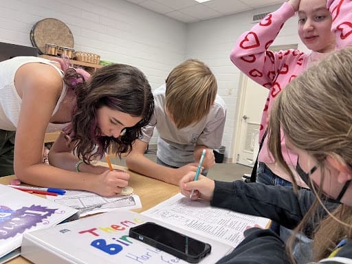 Students work on project together at table at micro school.