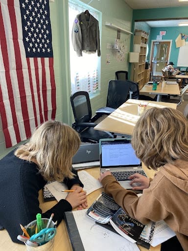 Two students work together at computer at part time school.