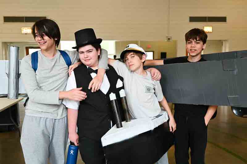 Four middle school boys wear outfits depicting characters from the early 20th century at project based school.