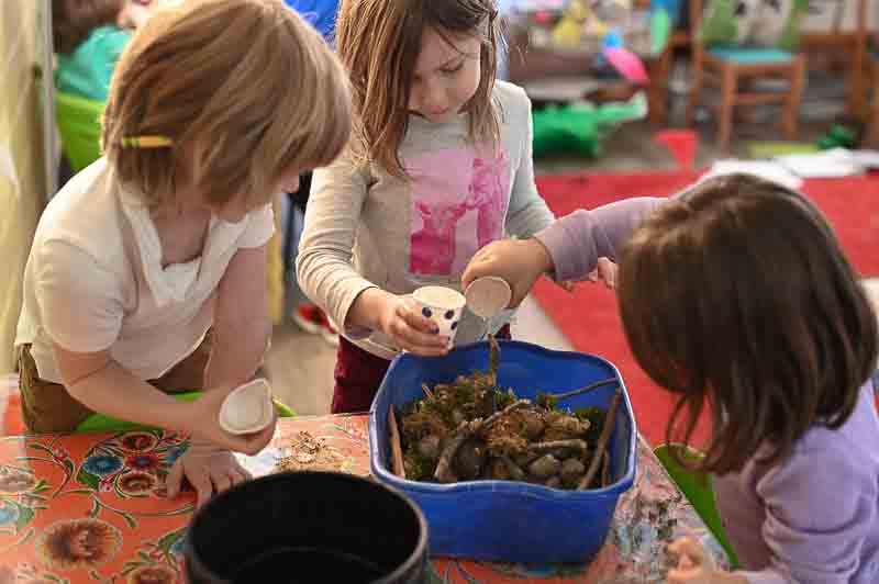 Three half day kindergarten students work on project together.