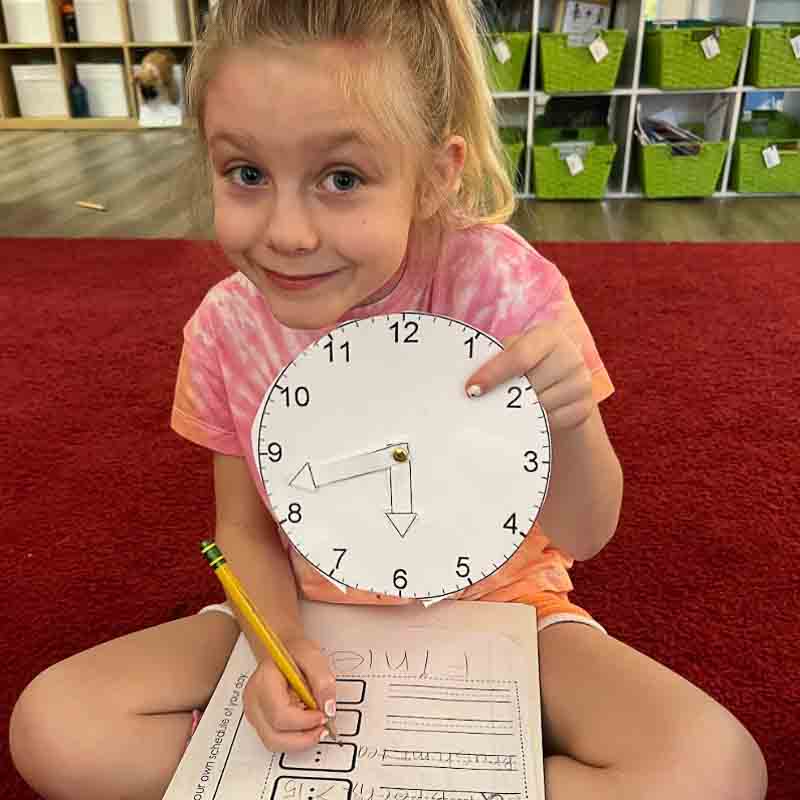 Girl displays time school work in small class.