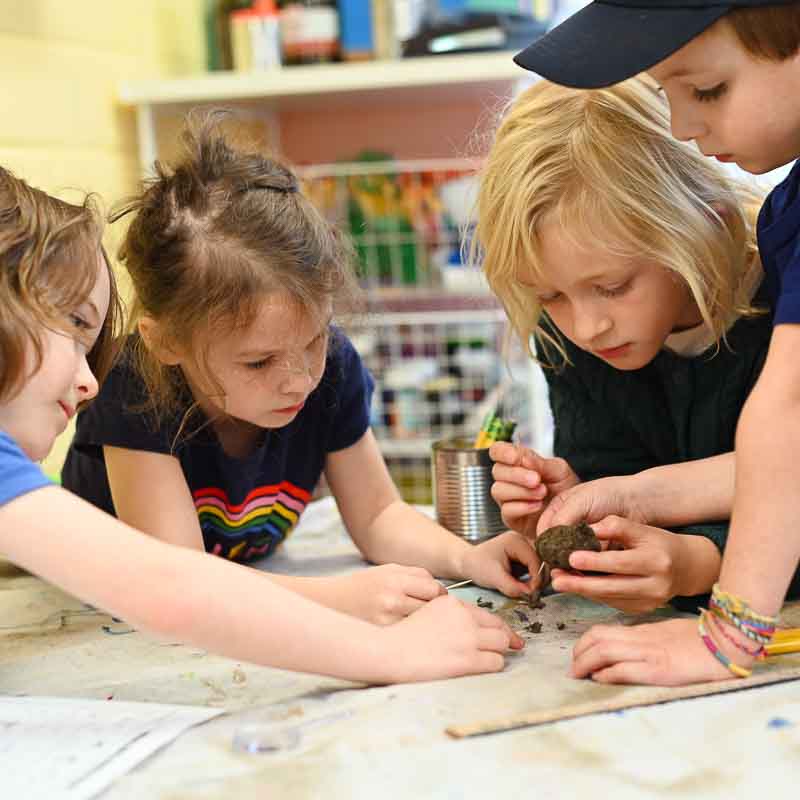 Four private school children work on science project together.