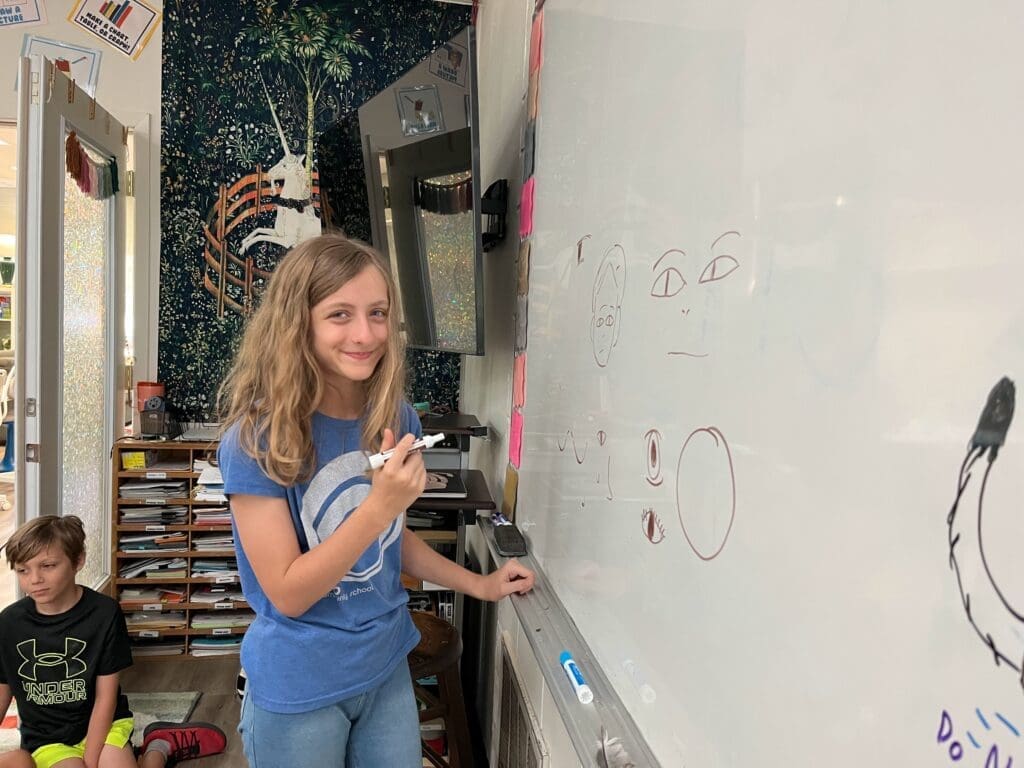 5th grader works at math board at STEM school.
