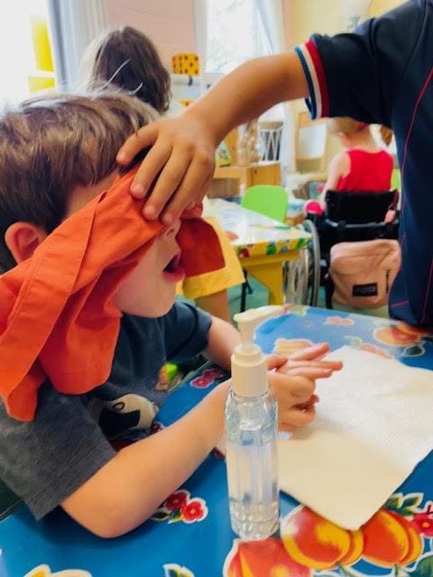 Student covers eyes of other student for science experiment at STEM school.