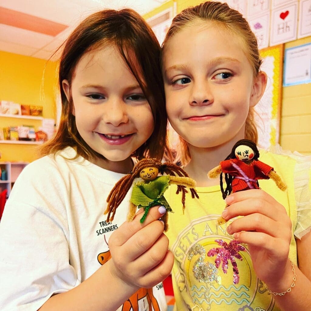 Second graders show off craft they made at progressive school.