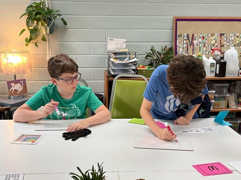 Fourth grade students work at a desk together at progressive micro school.