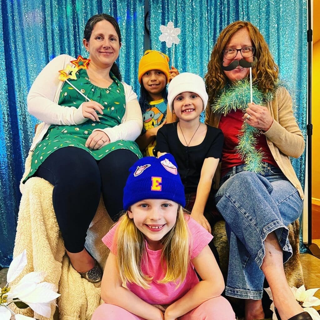 Teachers and students pose for Winter Faire fun at community school.
