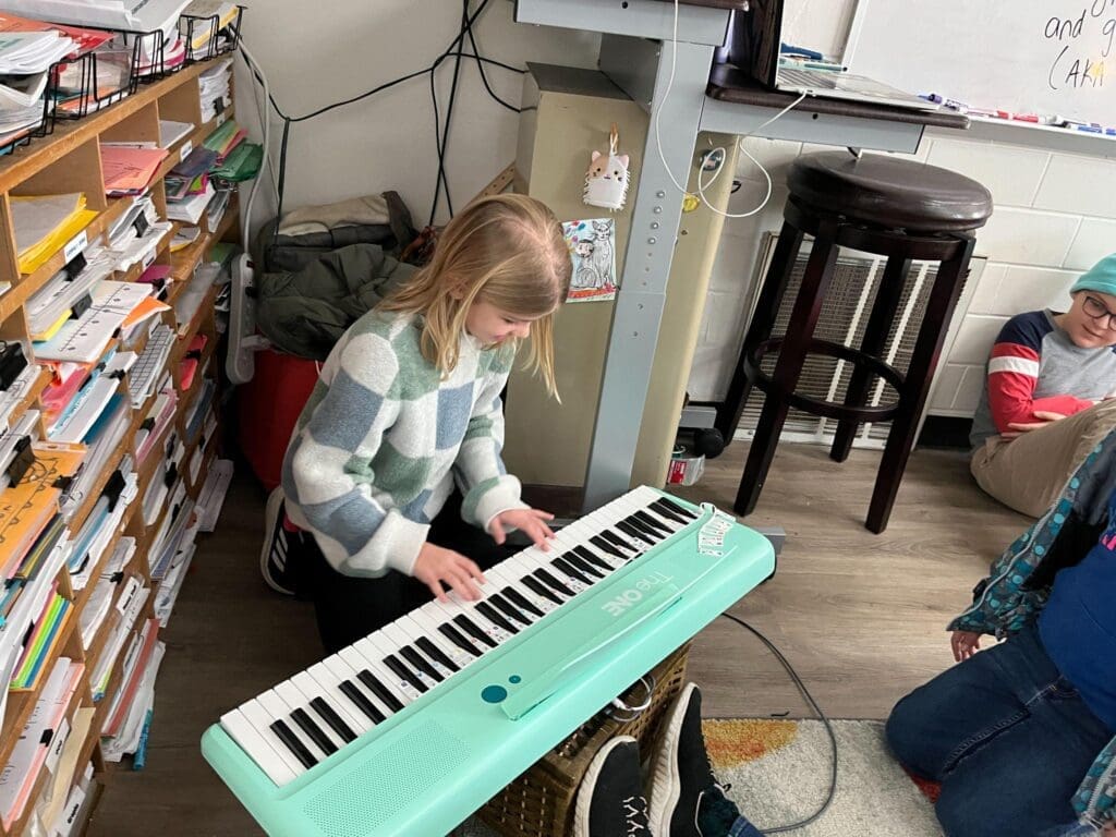 Fifth grade student plays piano at hands on school.