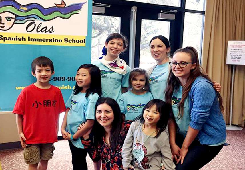 Two teachers pose with students at Spanish Immersion Friday enrichment program