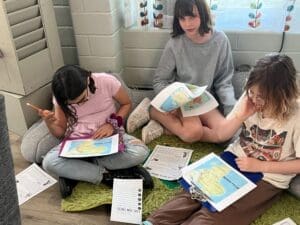 Three fifth grade girls work together at private school.