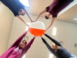 Four students hold ball to learn about physics and STEM middle school in Austin.