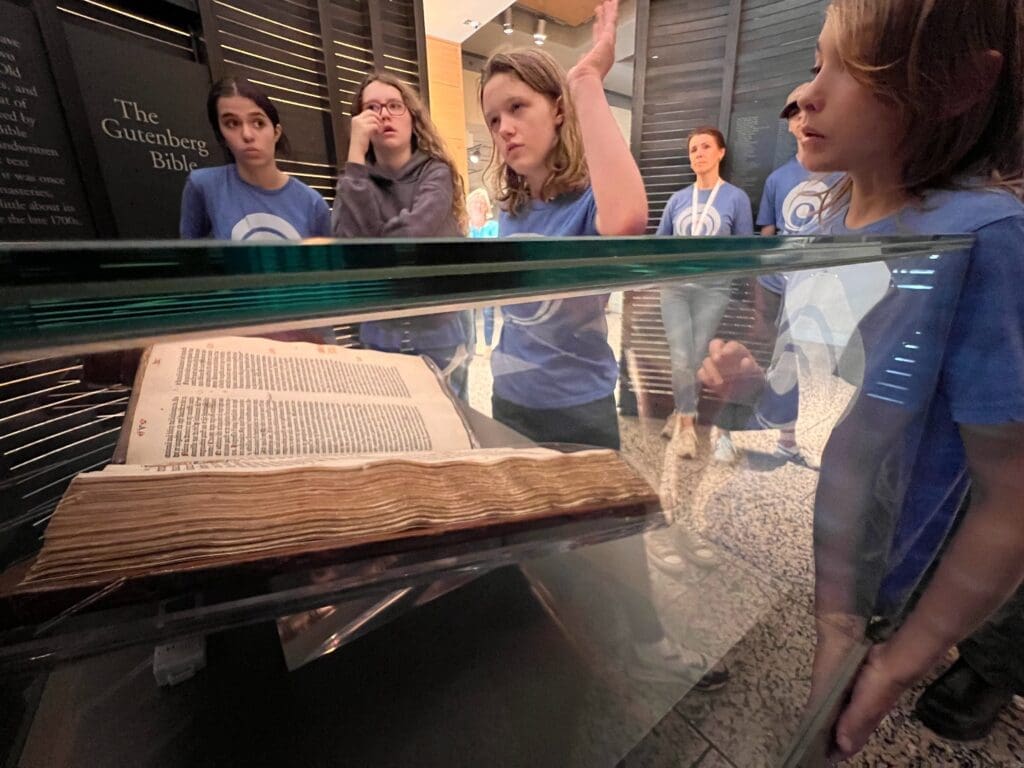 Middle school students visit Gutenberg bible on field trip at progressive private school.