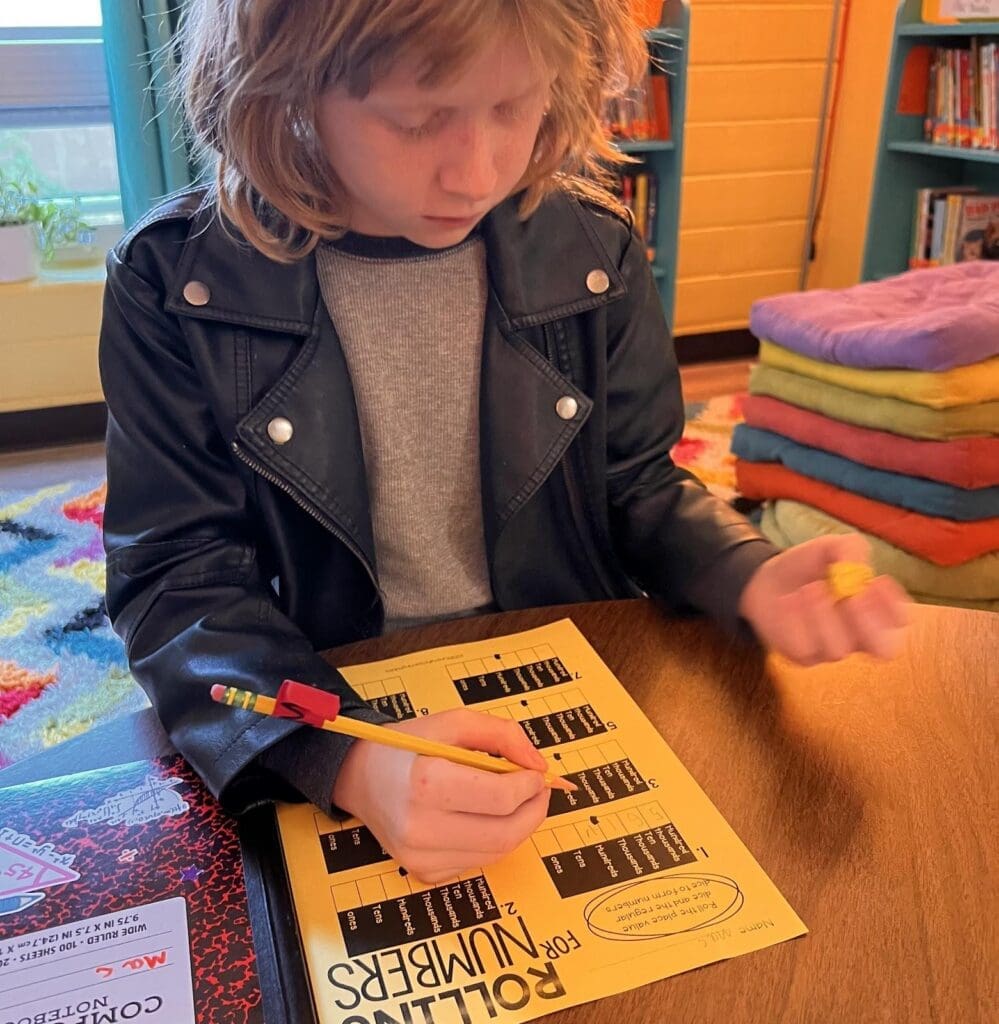 Second grader works on literacy at progressive school.