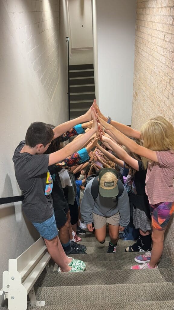 Middle school students form a bridge while other students walk under