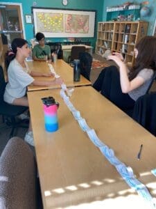 Three private middle school students work together at table to create STEM project.