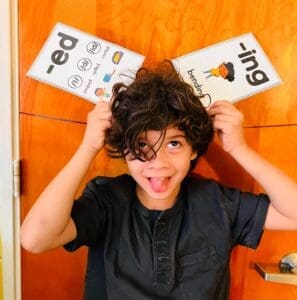 Second grade student holds reading cards at GT school in Austin.