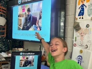 Fifth grade student points at tv screen at STEM school.