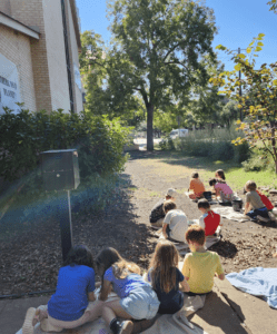 Kindergarten students work outside at part time school.