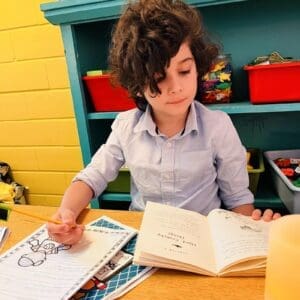 Second grade student reads and writes at GT school in Austin.