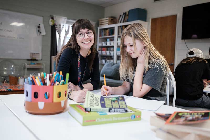 Austin Home Base Community School Elementary student works on writing skills at progressive school.
