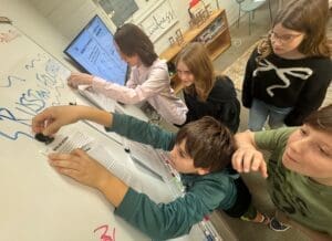 Middle school students work at board at micro school in Austin.