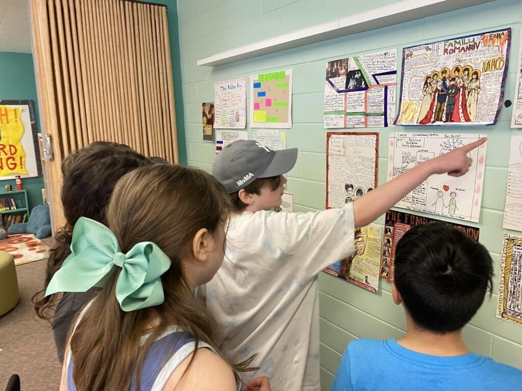 Middle school students point to project work at STEM school in Austin.