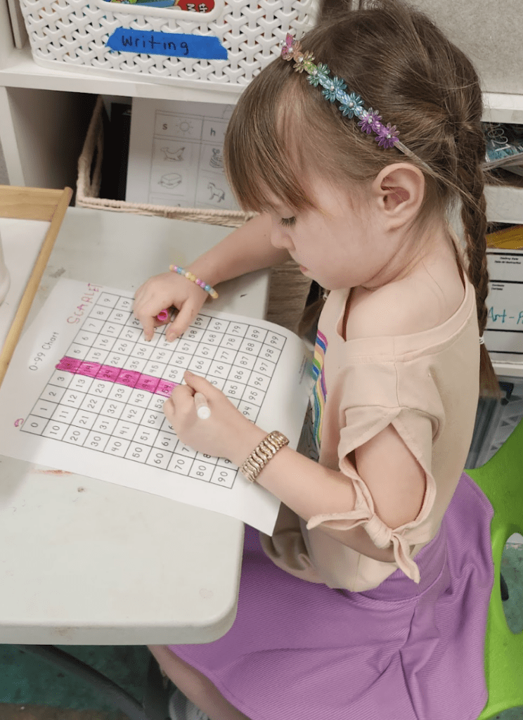 Kindergarten student works on innovative math work at school with small classes.