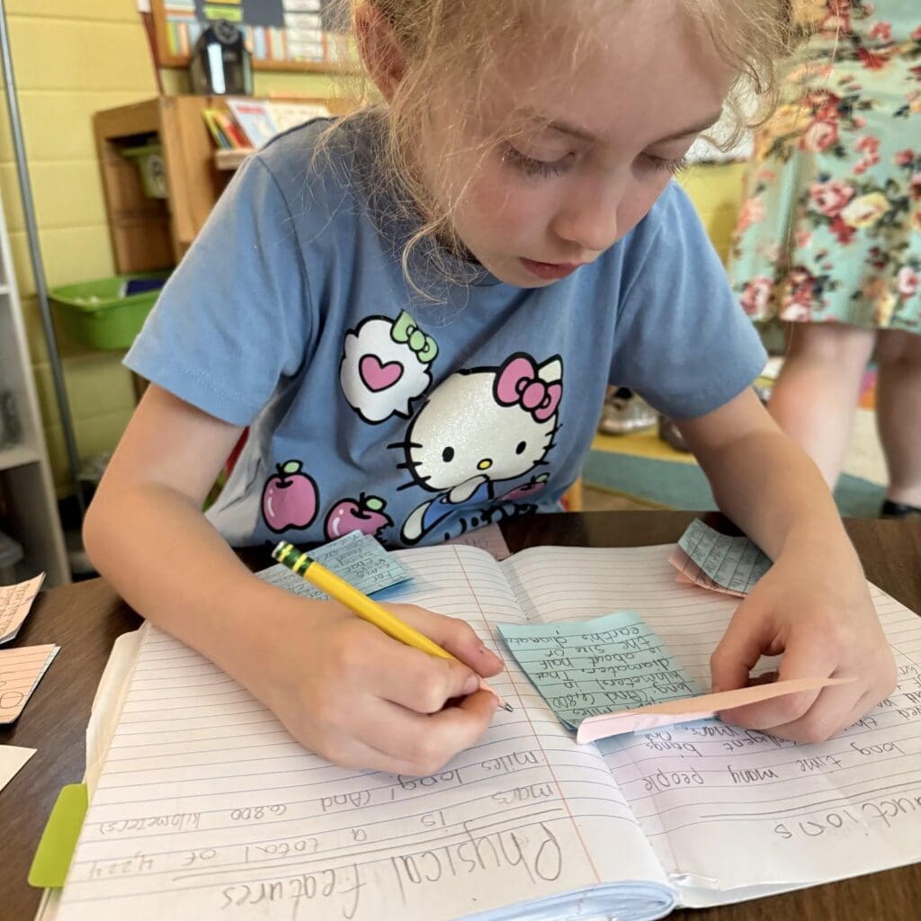 Elementary student uses post it notes on ELA work at private school in Austin.