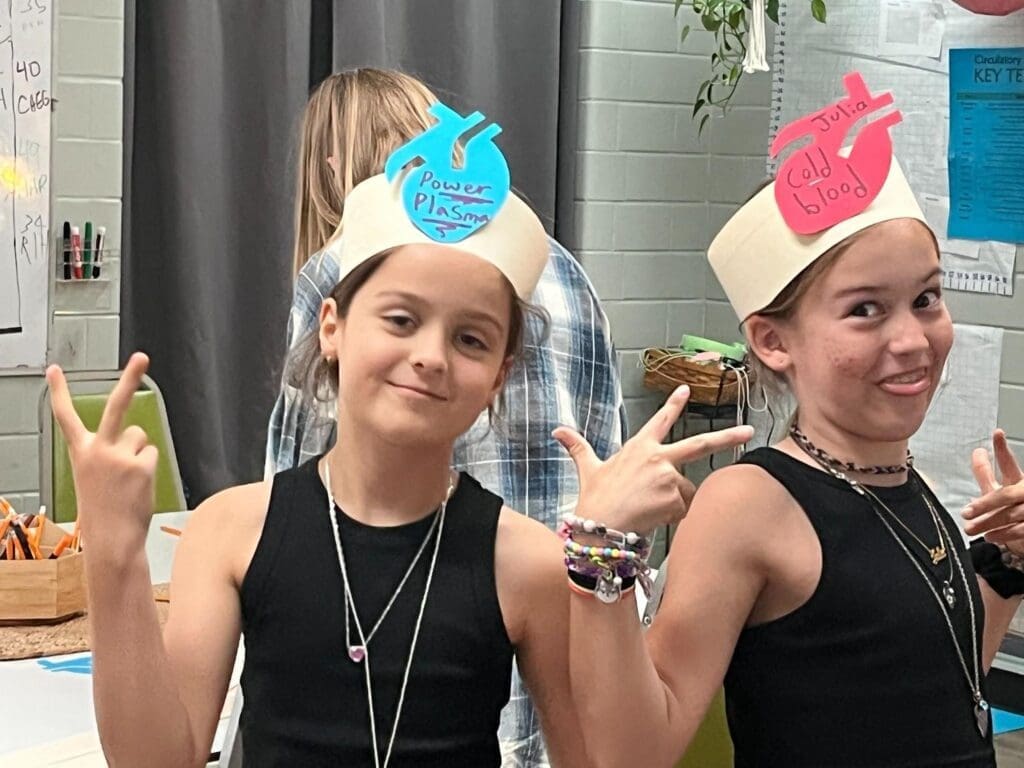 Two elementary girls dress up for project at GT school in Austin.