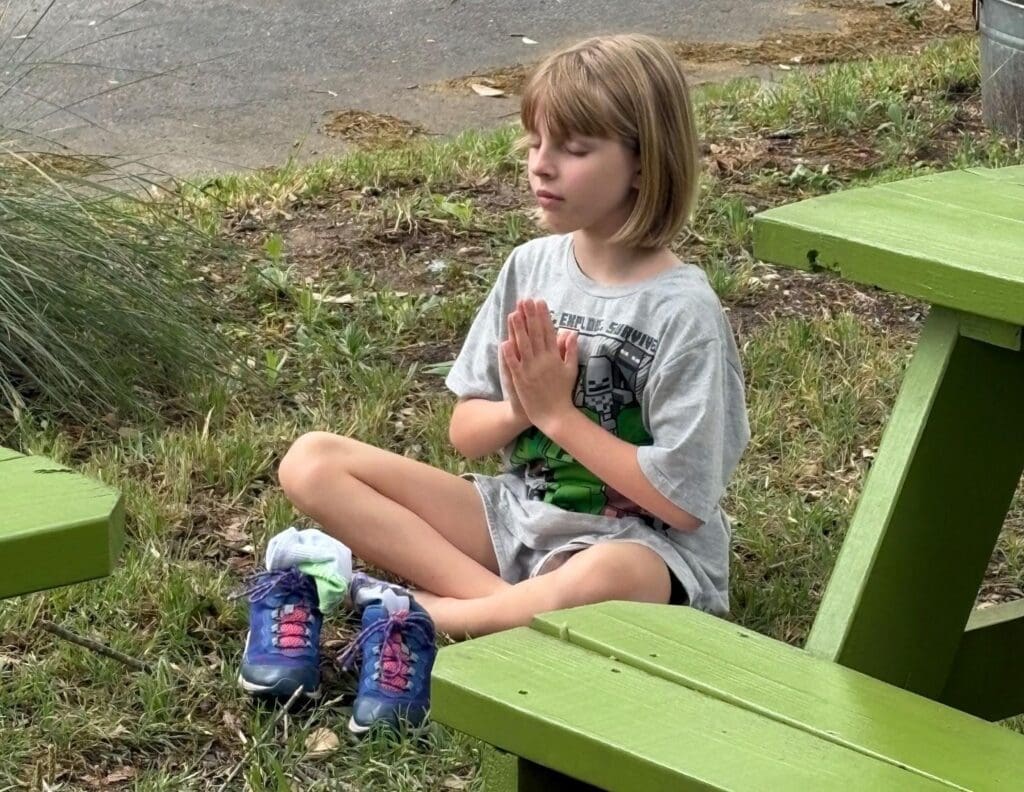 Elementary student meditates outdoors at private school in Austin.