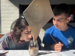Two middle school students inspect science experiment at microschool in Austin.