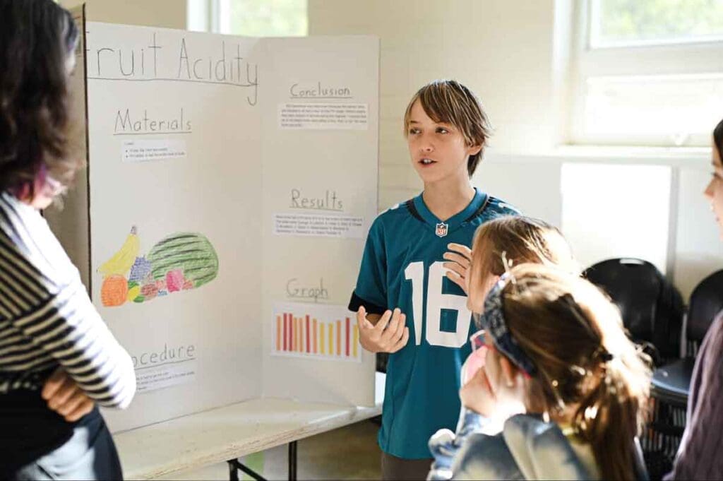 GT floating Student in gifted and talented program explains STEM project to middle schoolers.