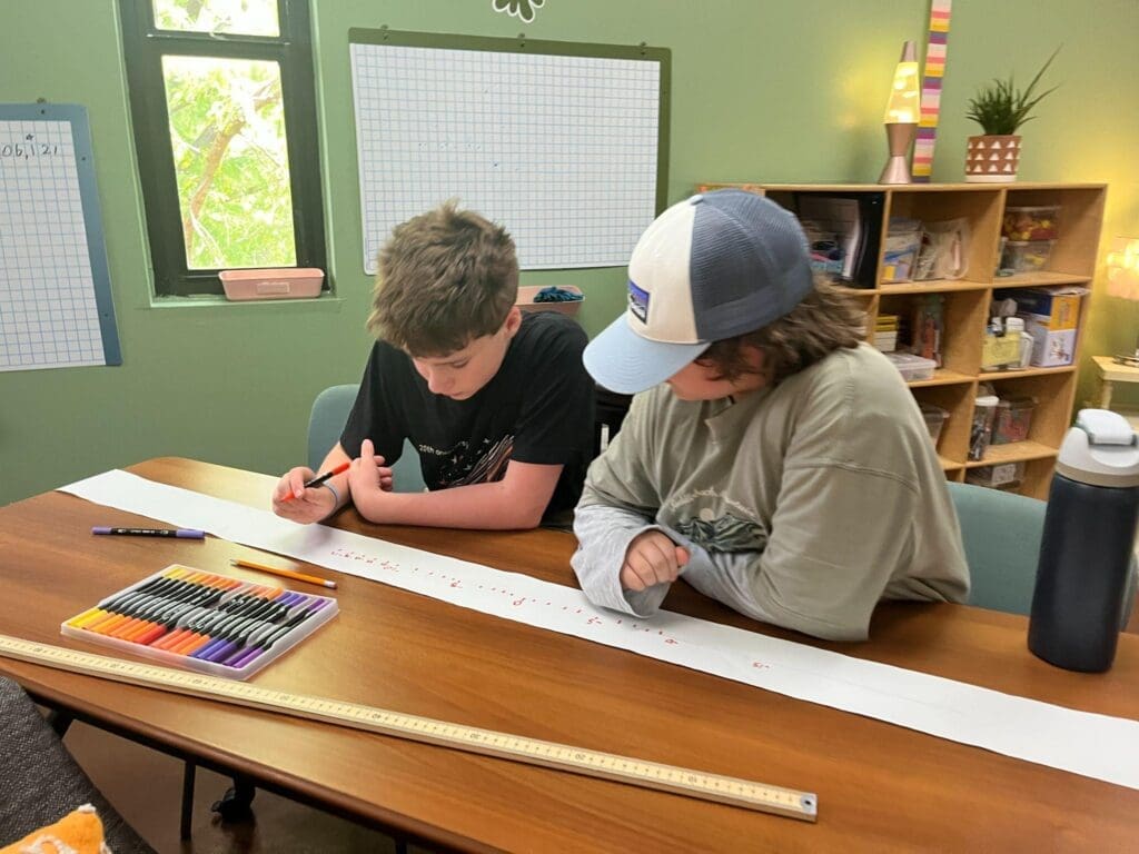 Two middle school students work on number line together at STEM school in Austin.
