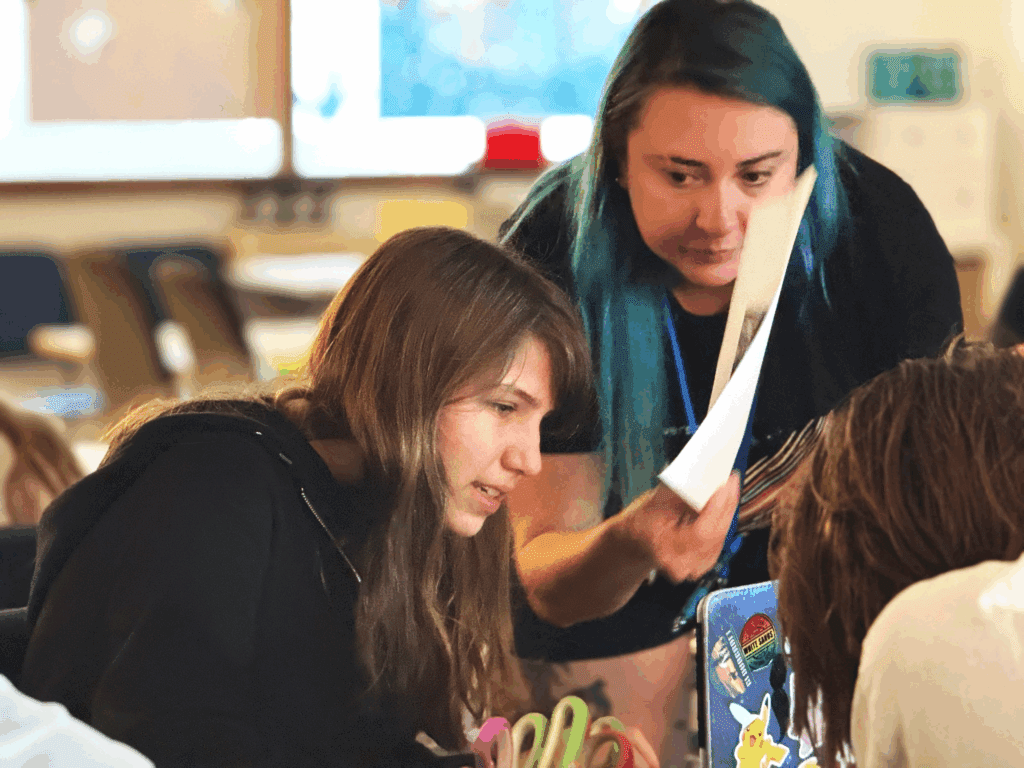 Middle school teacher works with student at school with small class size.