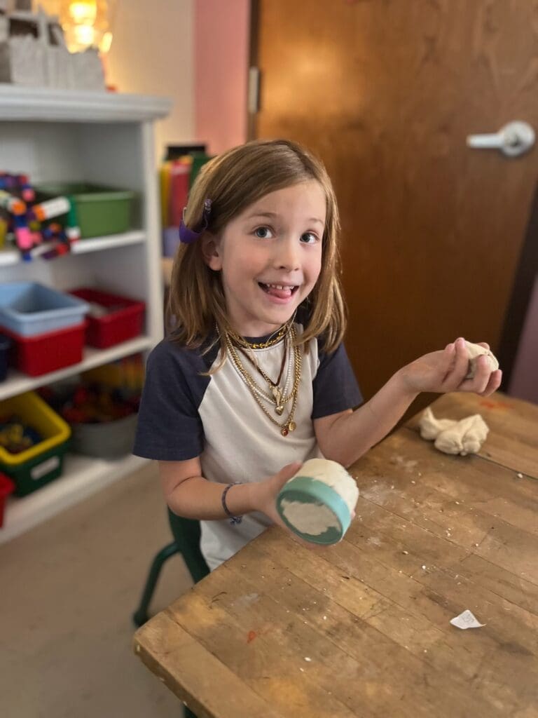 Elementary student molds clay at private school in Austin.