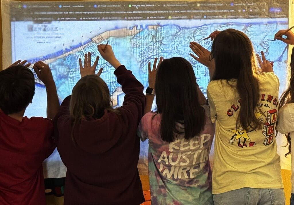 Middle school students work together on screen at project based school.