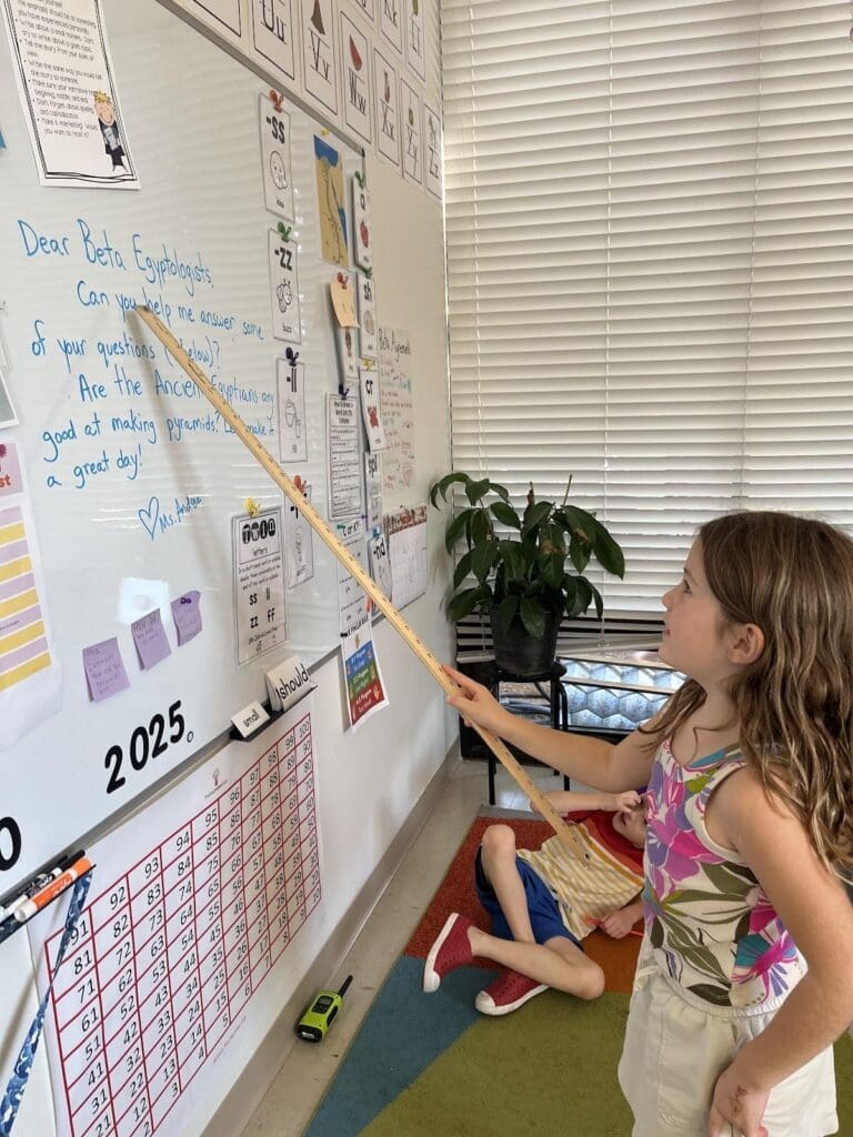 Elementary student points to white board at private school in Austin.