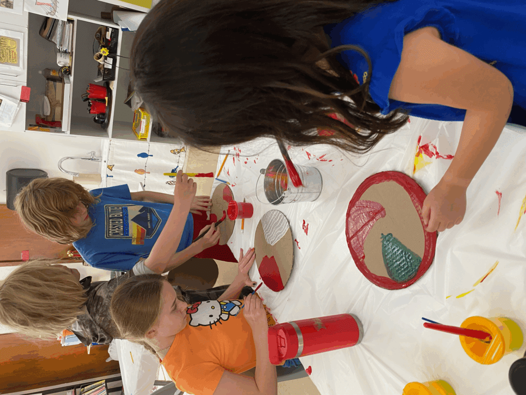 Elementary students paint at school with small classes.