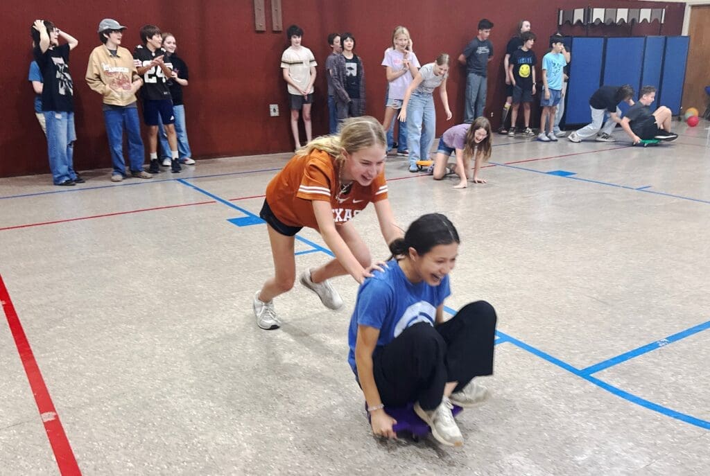Middle school students play in gym at school with small class sizes.