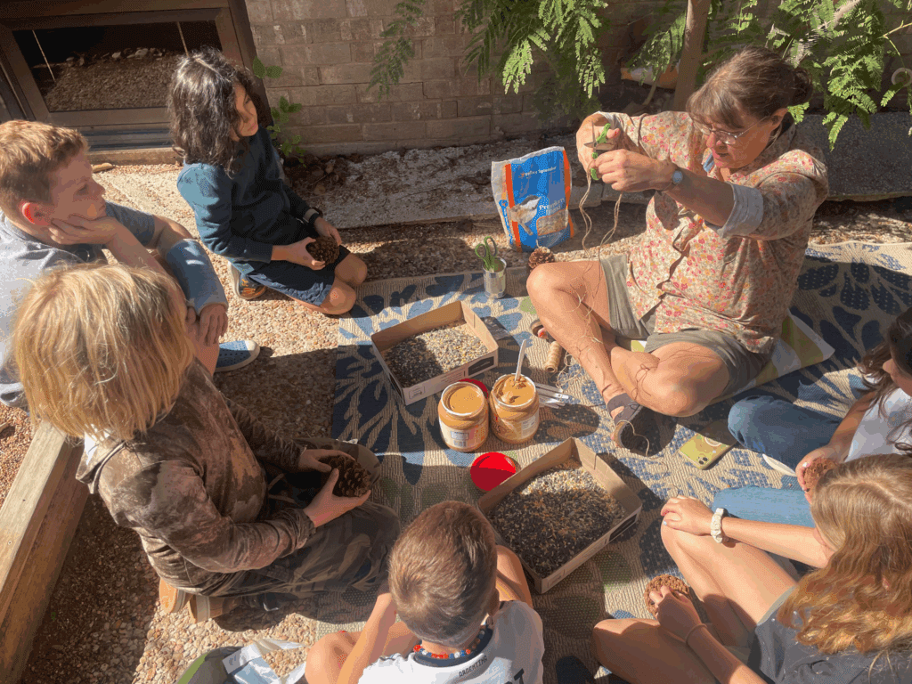Elementary teacher works outdoors with group at school with small class sizes.