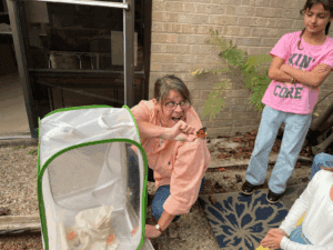 Elementary teacher shows students butterfly at STEM school in Austin.