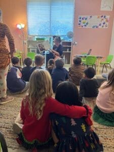 Kindergarteners sit together as teacher speaks at micro school.
