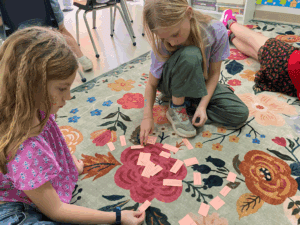 Three elementary students work on ELA at GT school.