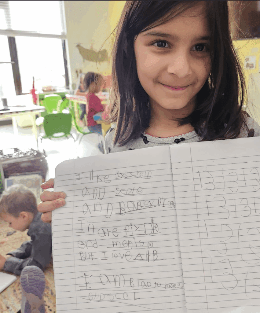 Kindergarten student displays writing at private school in Austin.