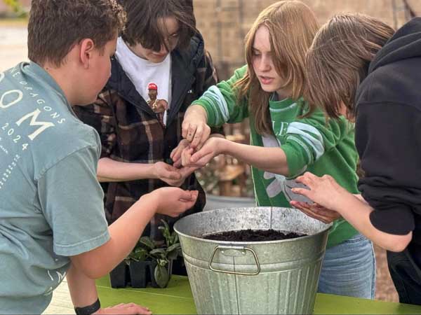 Middle school students work outdoors at project based school.