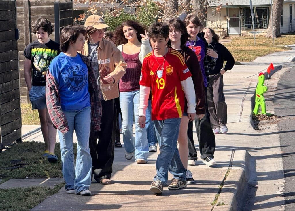 Middle school students walk together on sidewalk at micro school in Austin.