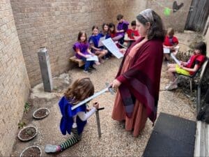 Elementary teacher knights student as part of project based learning.